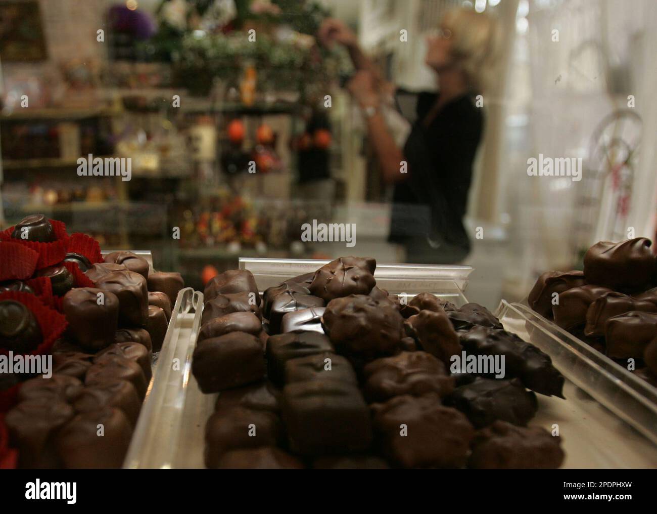 Deloris Verchere is seen through a display window as she arranges candy