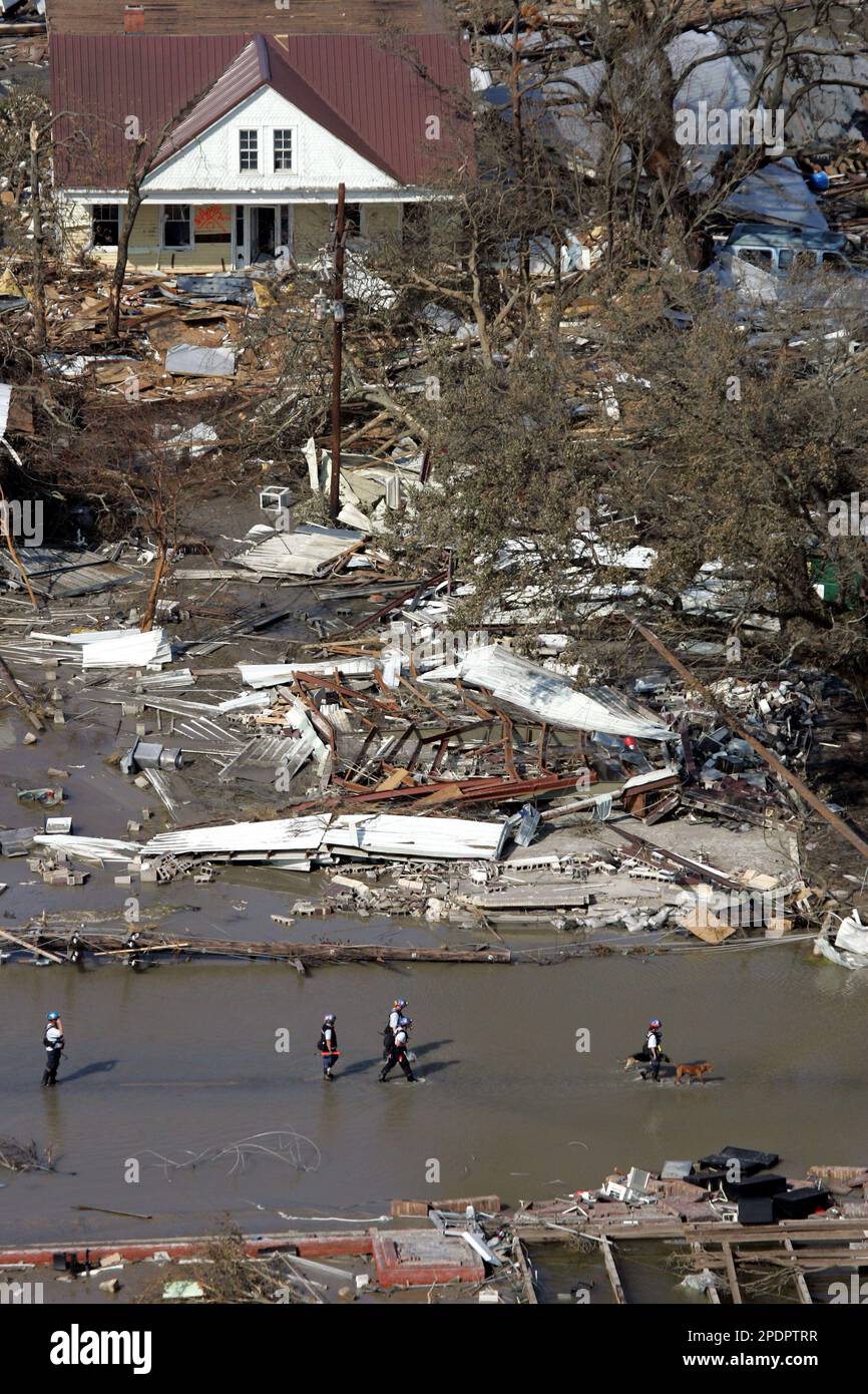 Search and rescue personnel walk through floodwaters in the aftermath ...