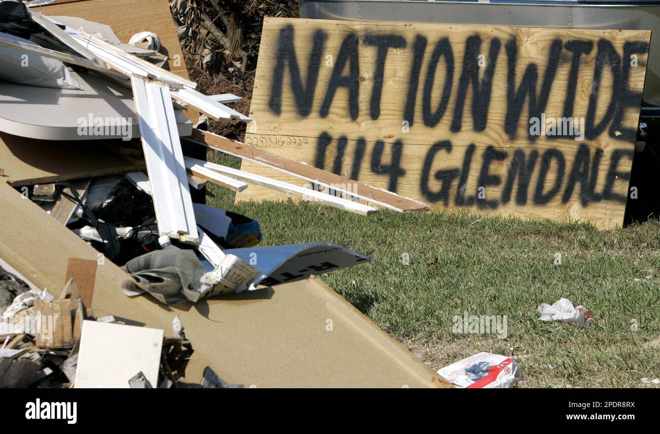 A sign left in near a pile of debris beckons a visti by an insurance  adjuster in Gulfport, Miss., Wednesday Sept. 21, 2005. The insurance  industry says it didn't insure for floods,