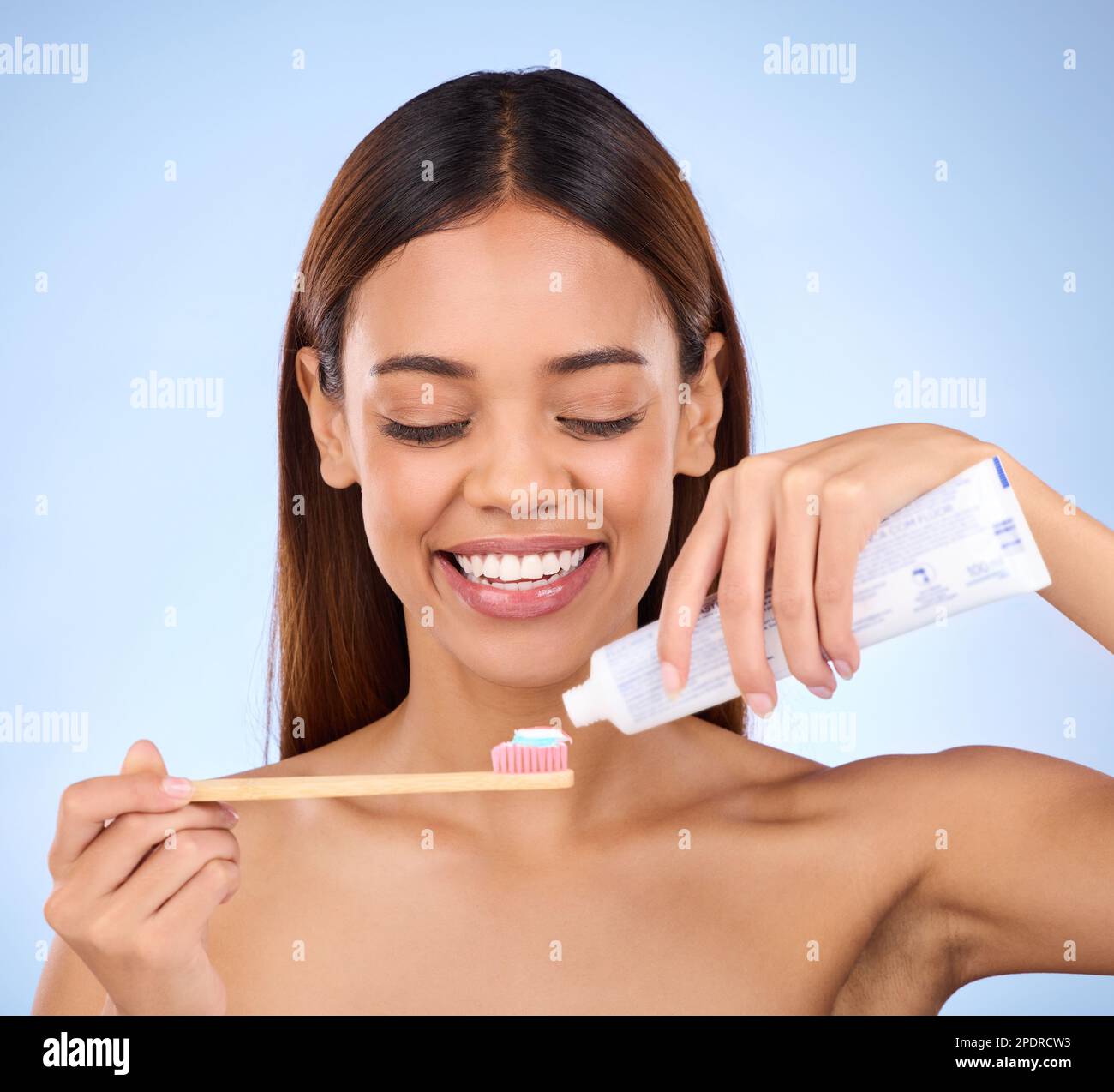 Toothbrush, toothpaste and dental with a woman in studio on a blue background for oral hygiene