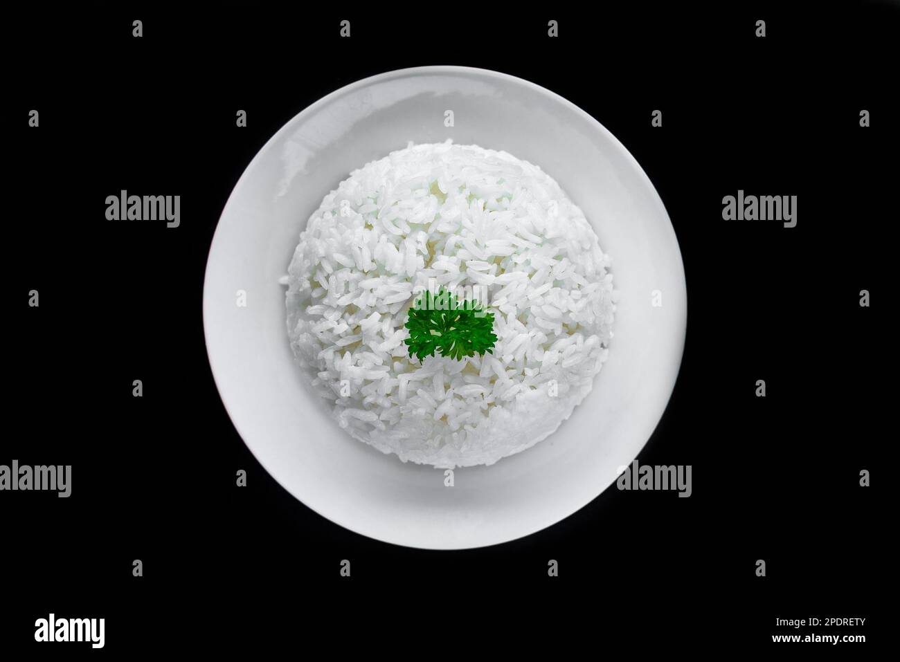 Plate with white rice, serving for Vietnamese dishes on black background Stock Photo