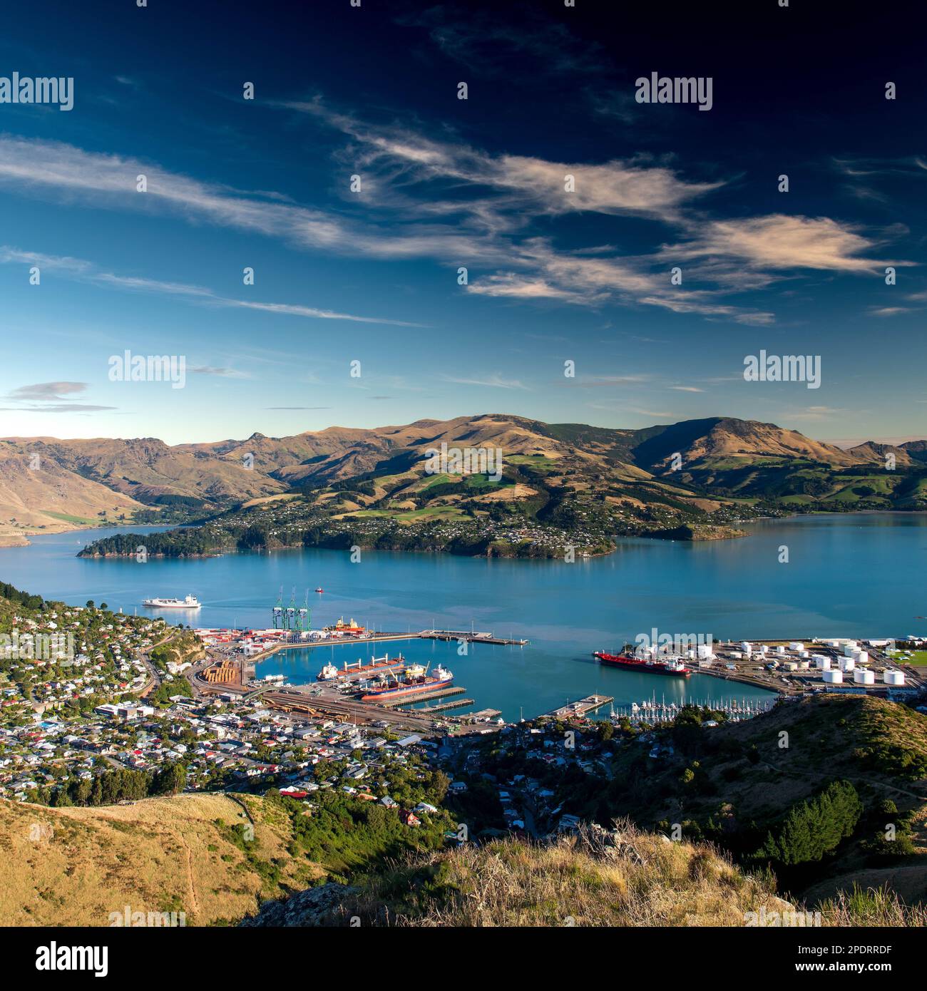 a square shot of the port-town of Lyttelton with the harbour in foreground and the rolling hills of New Zealand's South Island in the distance. Stock Photo