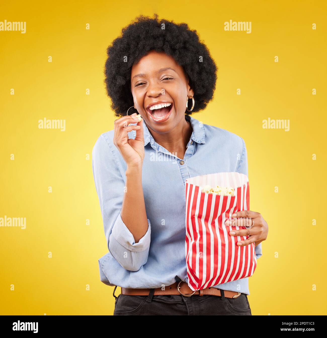 Happy, smile and popcorn with black woman in studio for movie, streaming service and cinema. Laugh, comedy and theatre with female and snack isolated Stock Photo