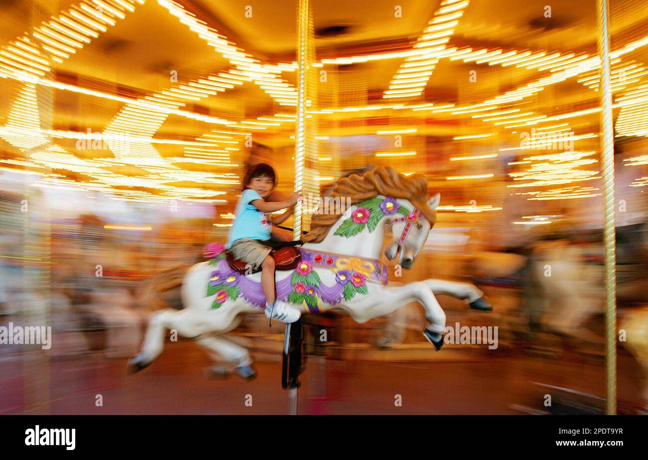 A boy enjoys a ride on the carousel at Hong Kong Disneyland as it
