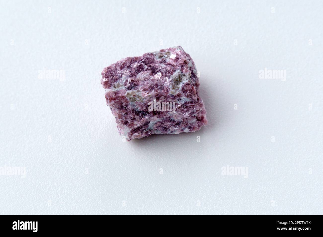 Mineral stone lepidolite. Macro shooting of natural gemstone. The raw mineral, white backround Stock Photo