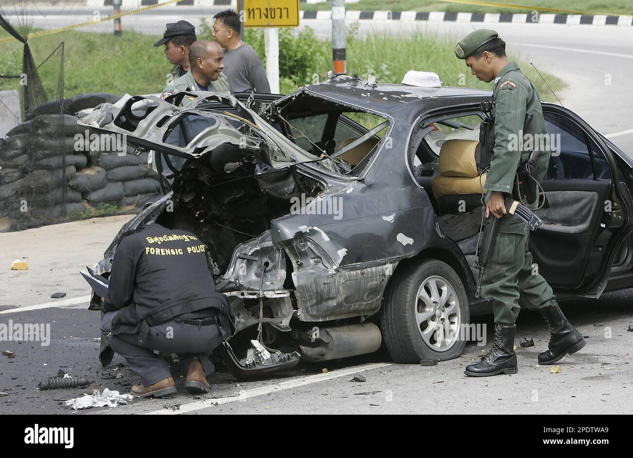 Thai police officers and forensic experts examine a car which was ...