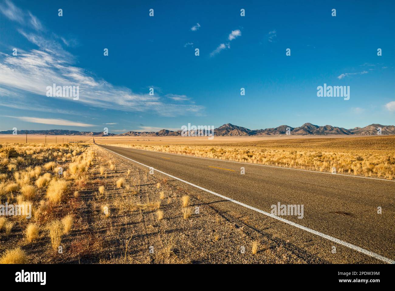 15 miles long straight line of Grand Army of the Republic Highway (US 6), Hot Creek Range in distance, Great Basin Desert, east of Tonopah, Nevada USA Stock Photo