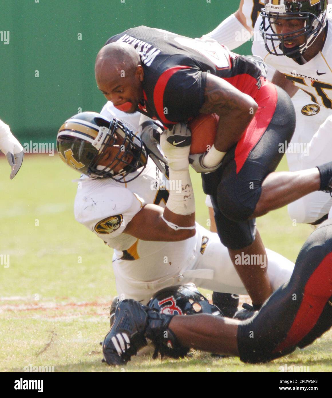 Arkansas State running back Antonio Warren, center, loses his helmet after  he was hit by Missouri's Brian Smith, left, as Missouri's Elgin Childress,  right, moves in during the first half Saturday, Sept.