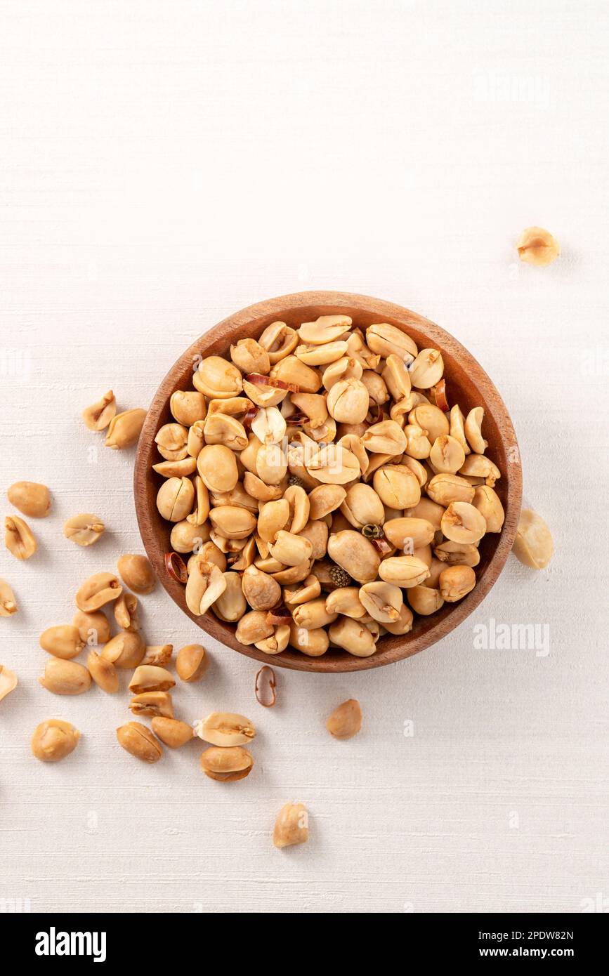 Spicy flavored peanut kernel in a bowl on white table background. Stock Photo