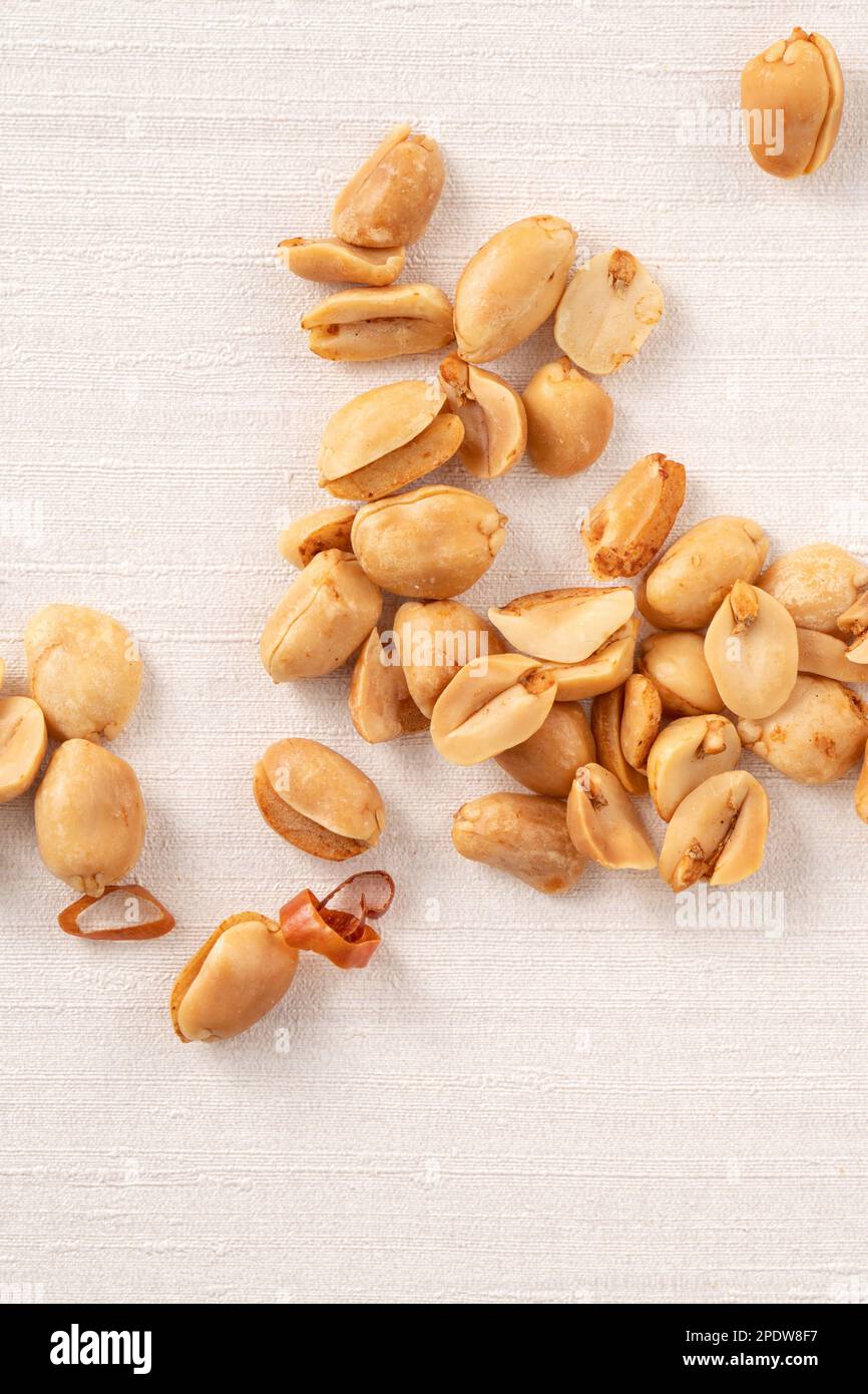 Spicy flavored peanut kernel spilling on white table background. Stock Photo