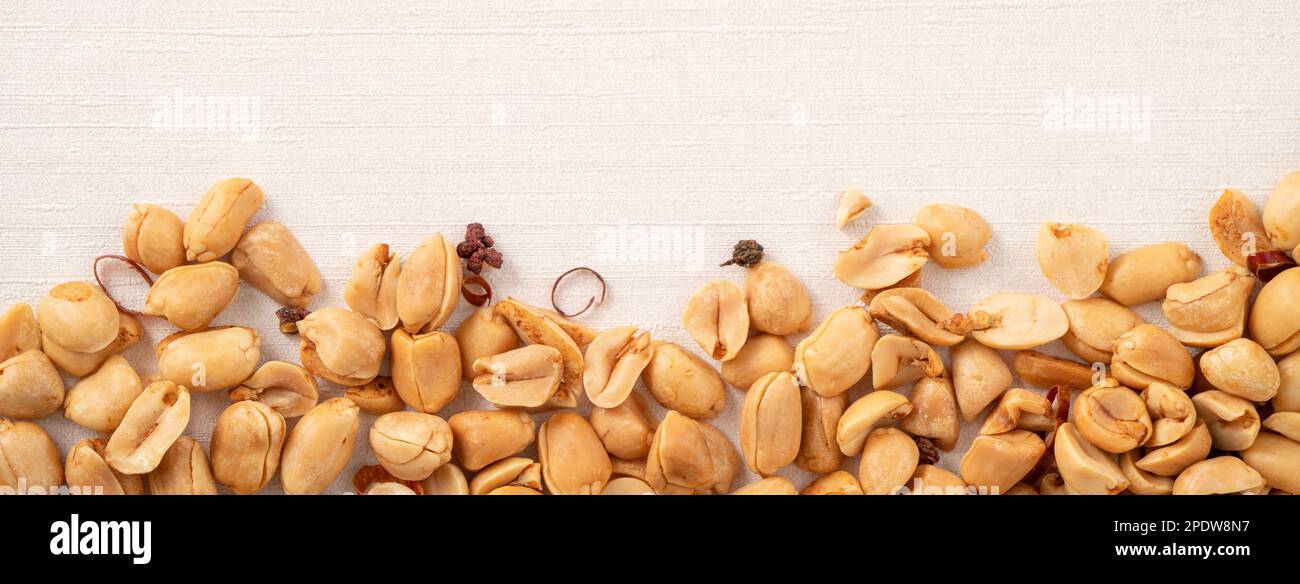 Spicy flavored peanut kernel spilling on white table background. Stock Photo