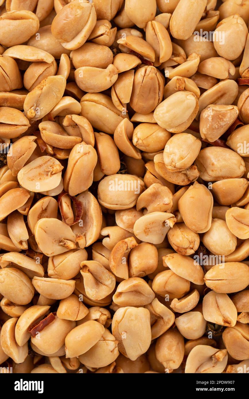 Spicy flavored peanut kernel spilling on white table background. Stock Photo