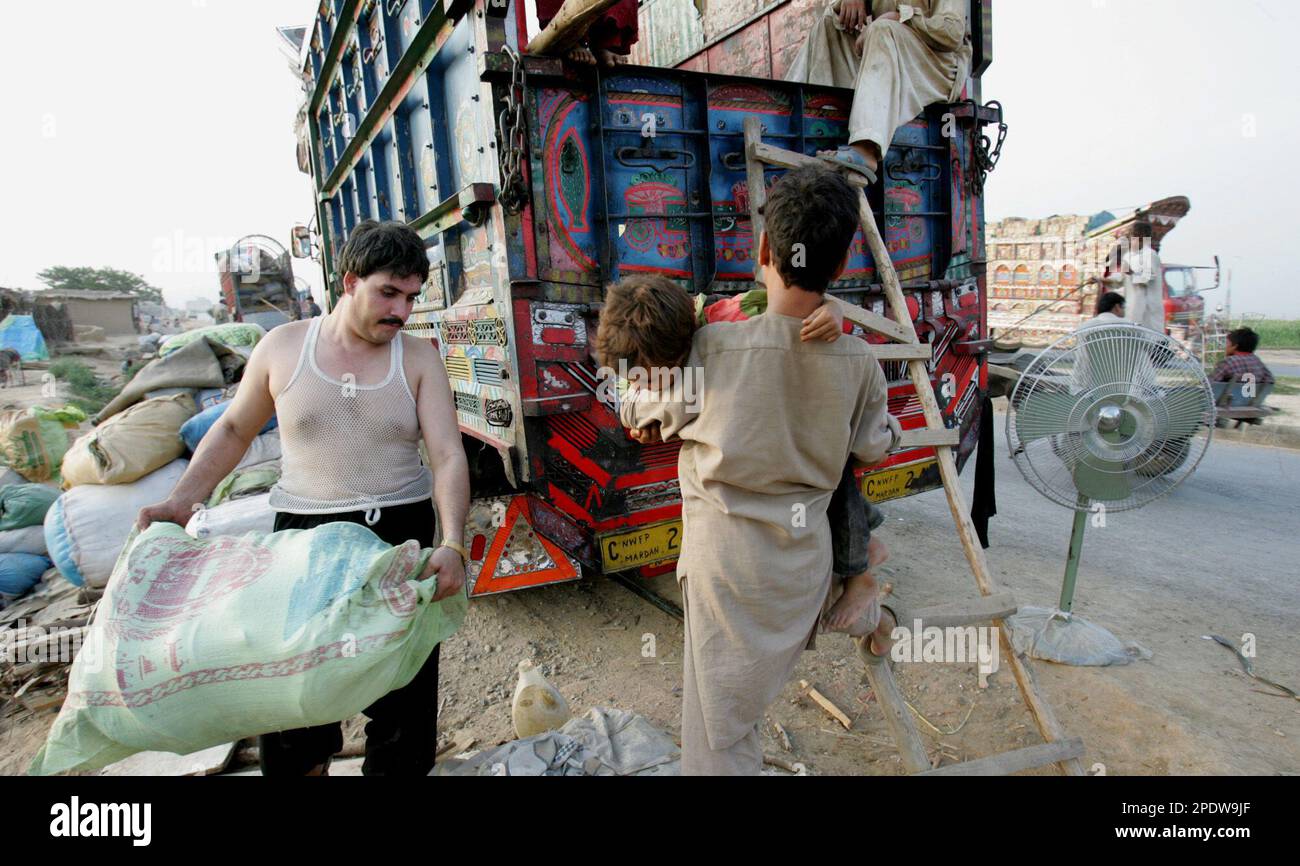 An Afghan refugee Rasheed, left, from eastern Pagman province, loads ...