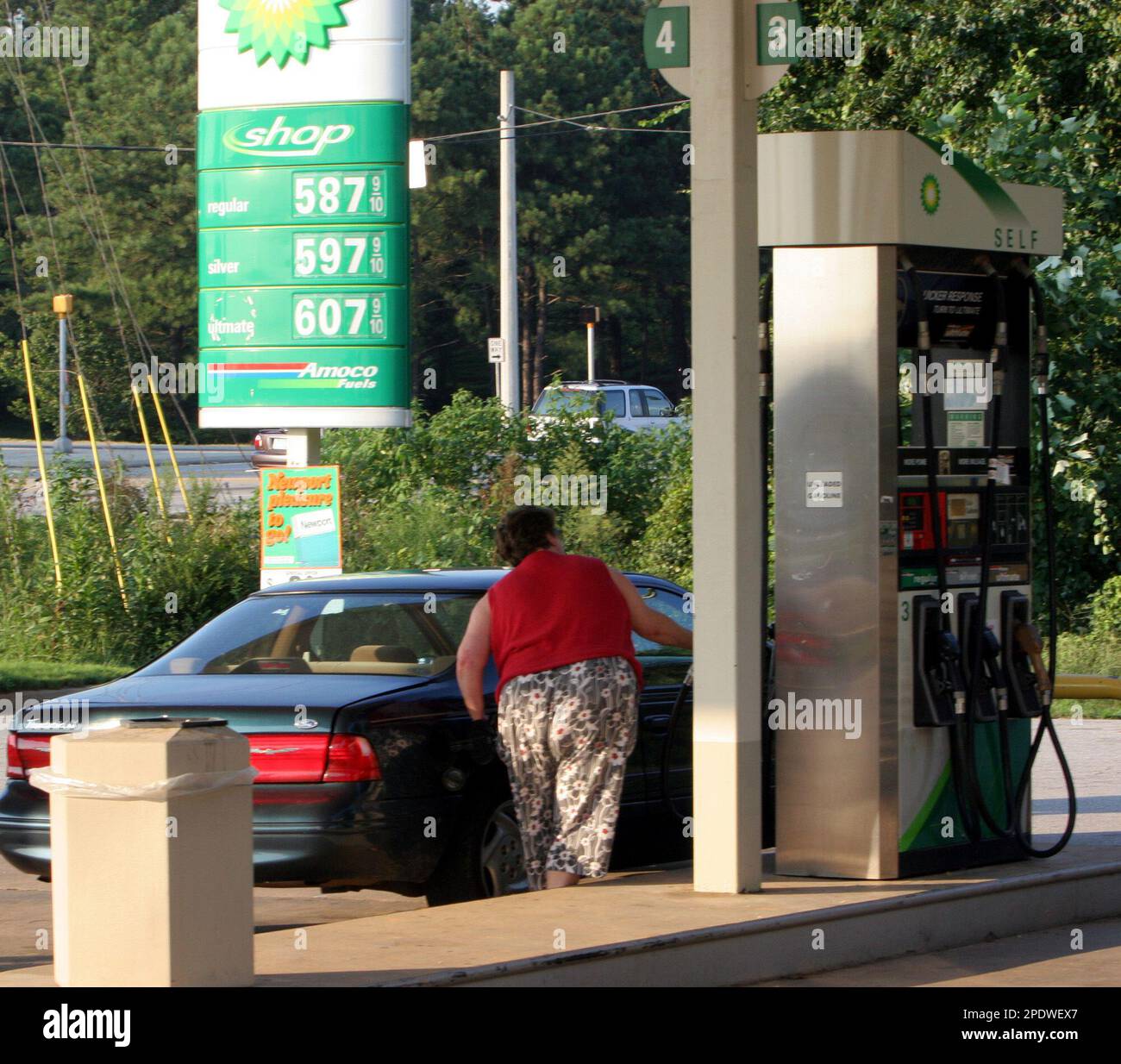 An unidentified gas customer returns to her car afer checking prices on