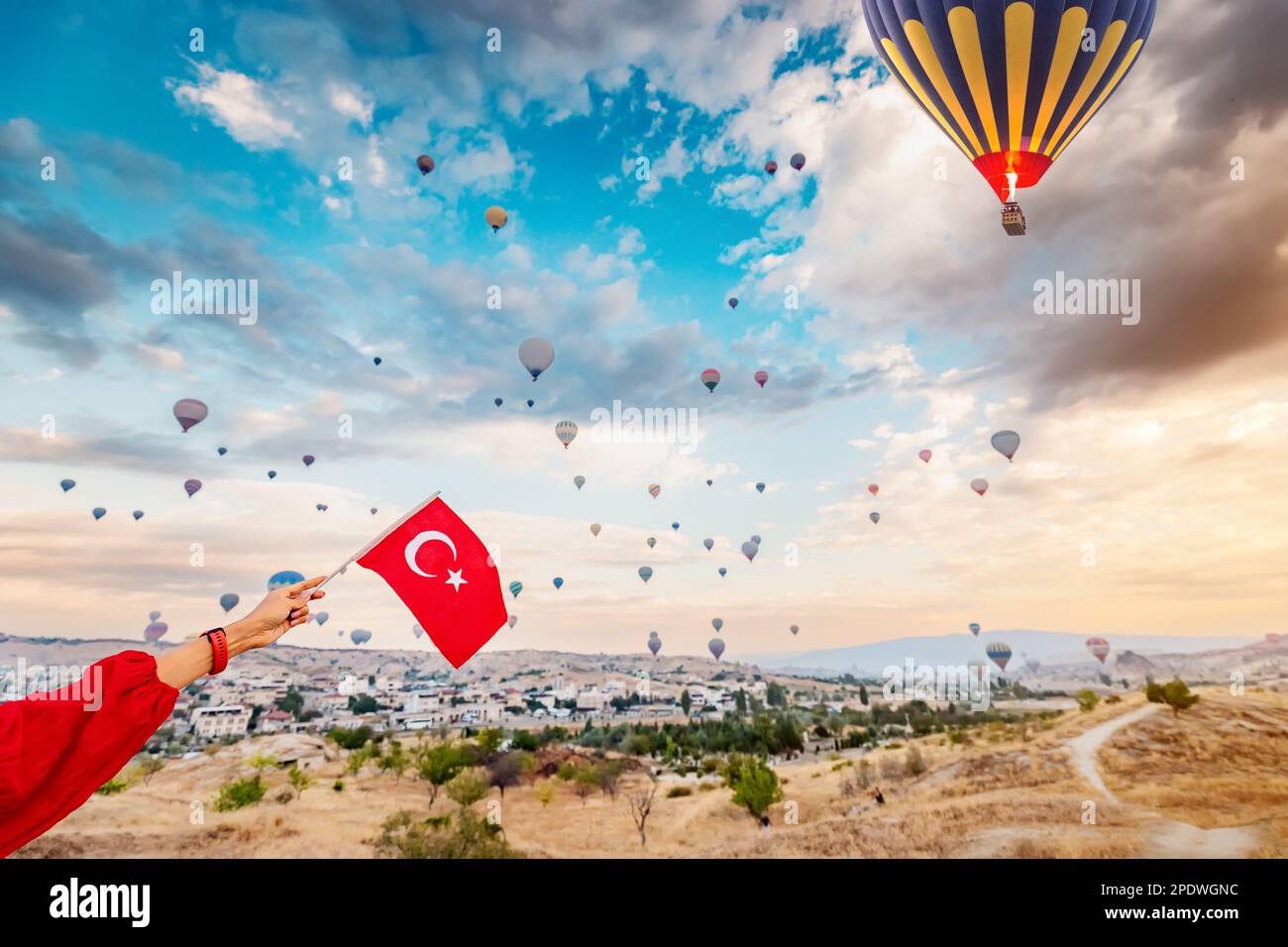 Experience the beauty and culture of Turkey through the eyes of a young woman as she watches the hot air balloons of Cappadocia soar and displays the Stock Photo