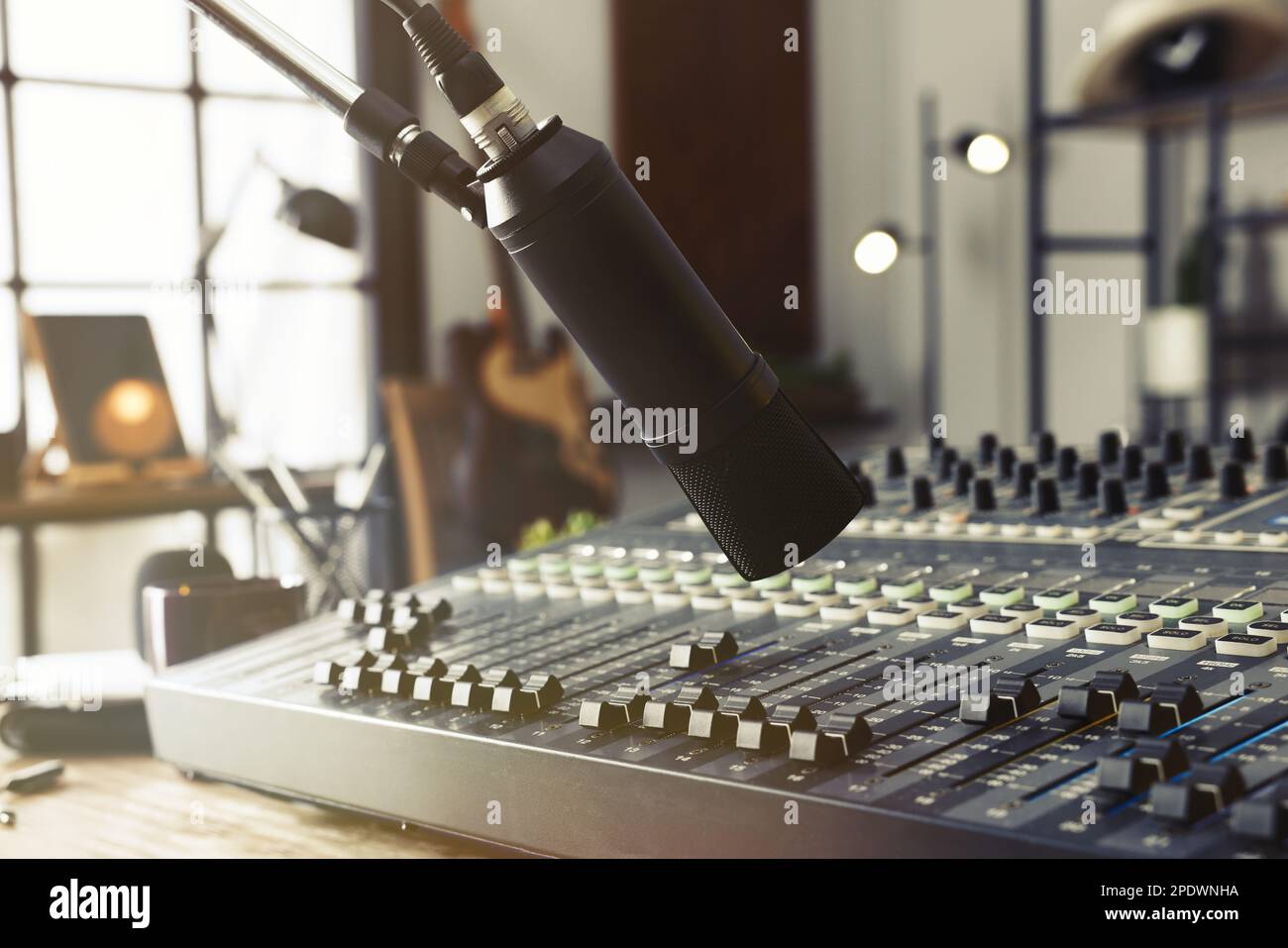 Microphone near table with professional mixing console in radio studio ...