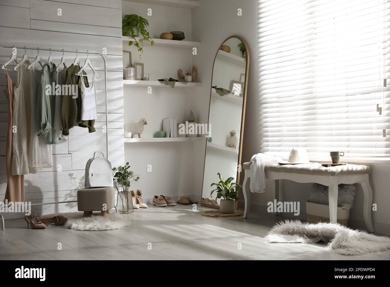 Rack with different stylish clothes, shoes and decorative elements in ...