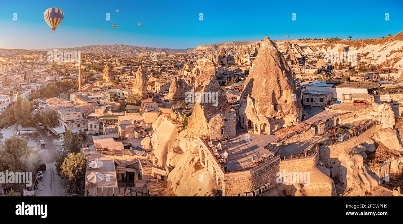 Scenic aerial panoramic view of smooth flying and floating hot air balloons among carved houses and hotels in Cappadocia Turkish wonder Stock Photo