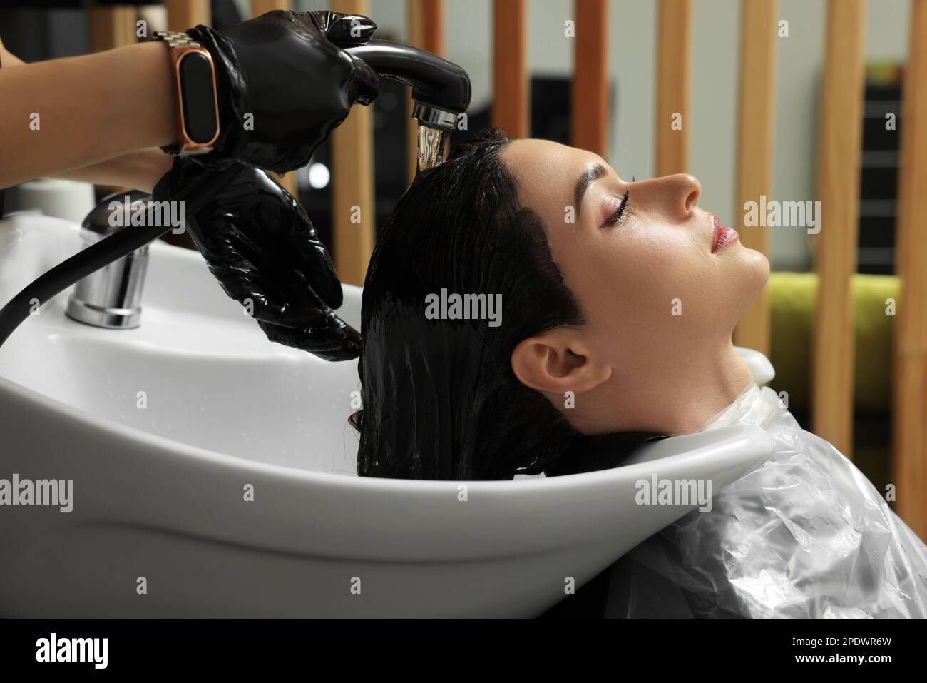 Hairdresser rinsing out dye from woman's hair in beauty salon Stock Photo Alamy