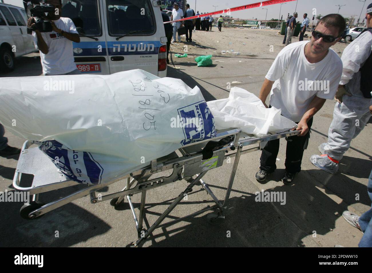 Israeli rescue worker evacuates the wrapped remains of a suicide bomber ...
