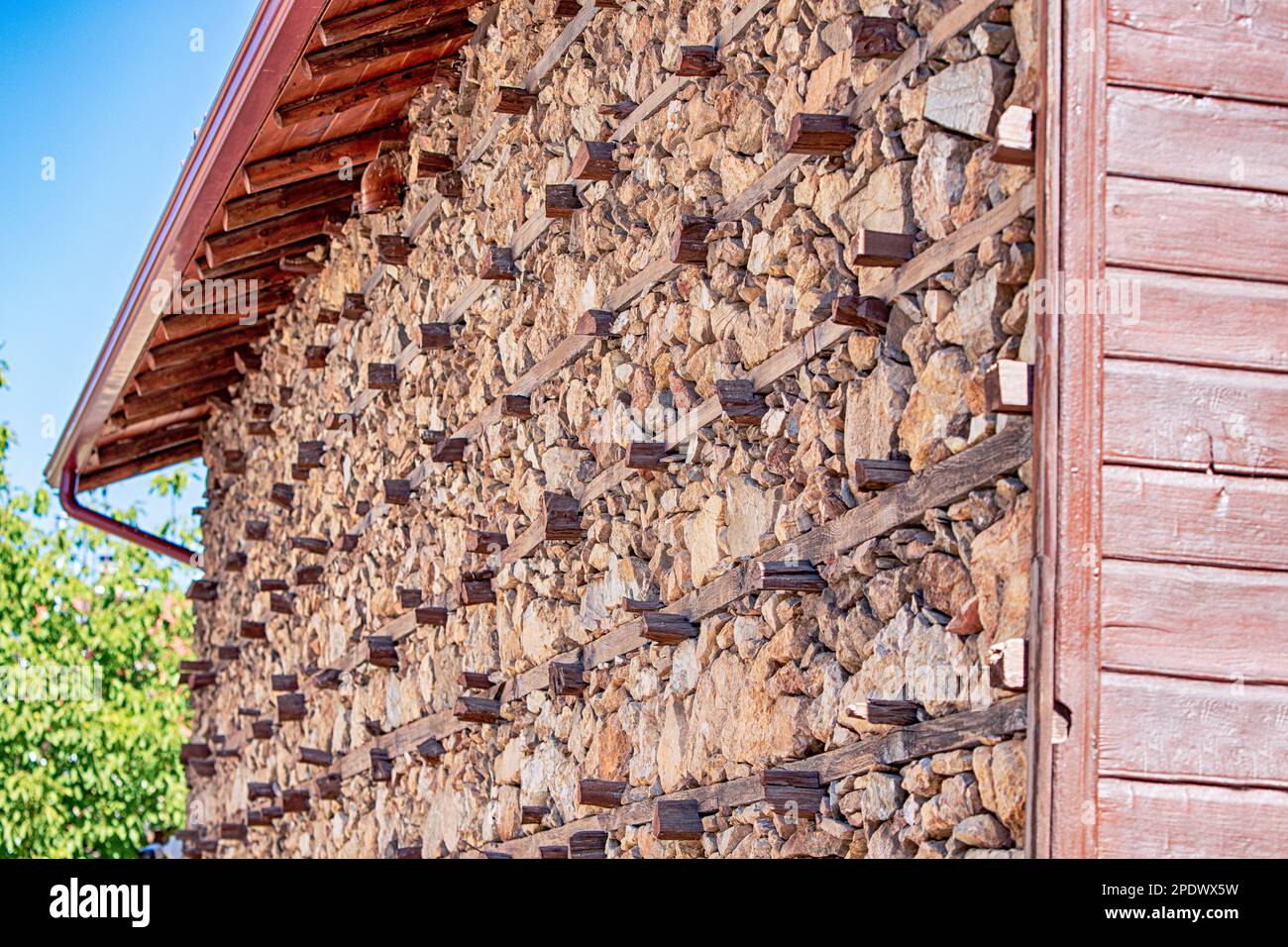 Buttoned rustical house wall made of stones and wood high in mountains ...