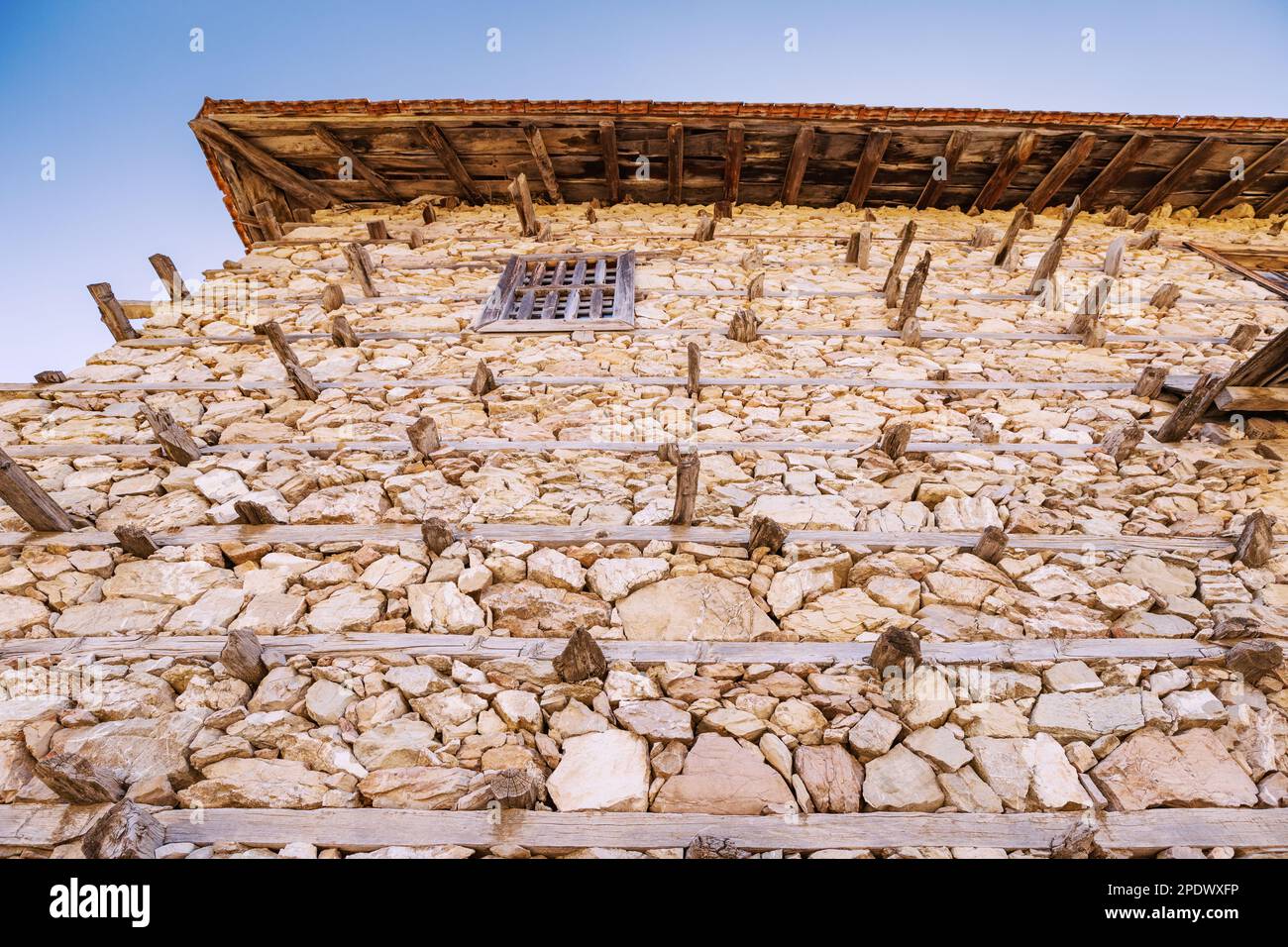 Buttoned rustical house wall made of stones and wood high in mountains ...