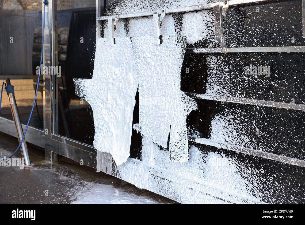Auto mats covered with foam hanging at car wash Stock Photo Alamy