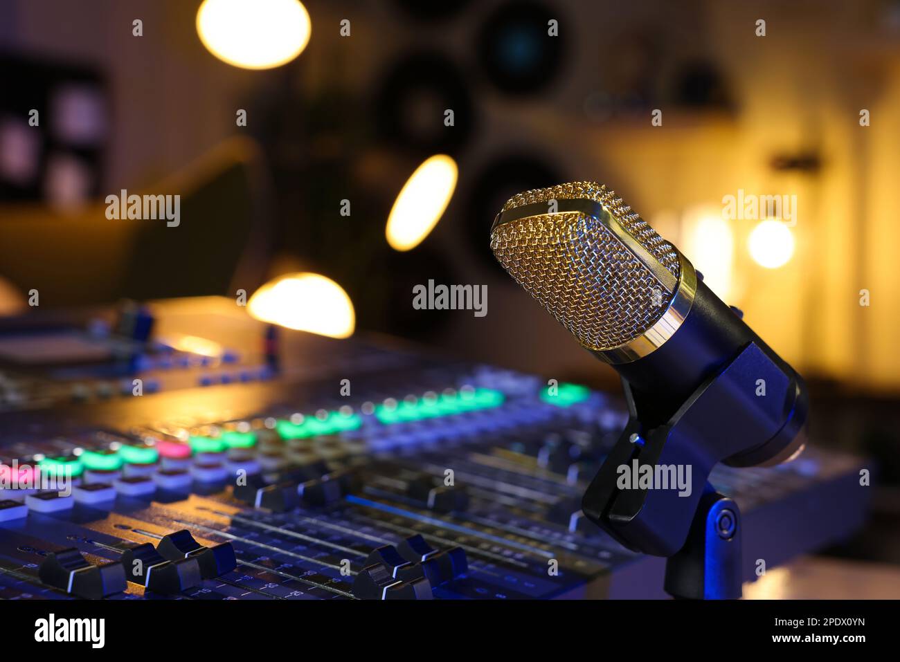 Microphone near professional mixing console in radio studio, closeup