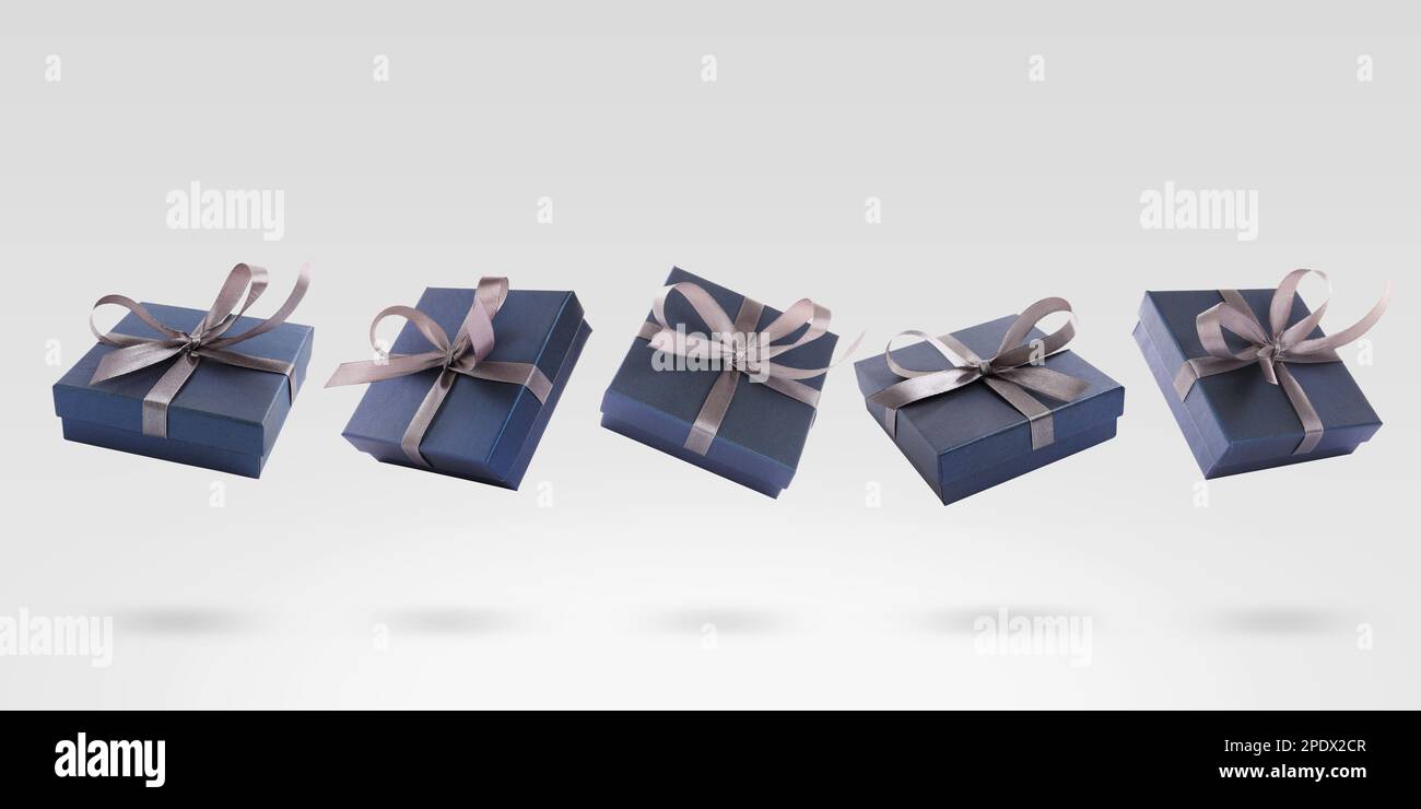 Beautifully wrapped gift boxes flying on light background Stock Photo