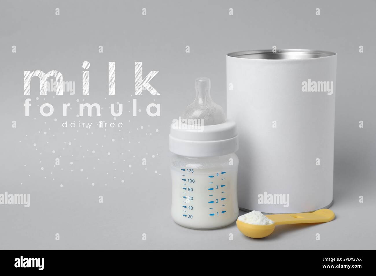 Blank can of powdered dairy free infant formula with scoop and feeding