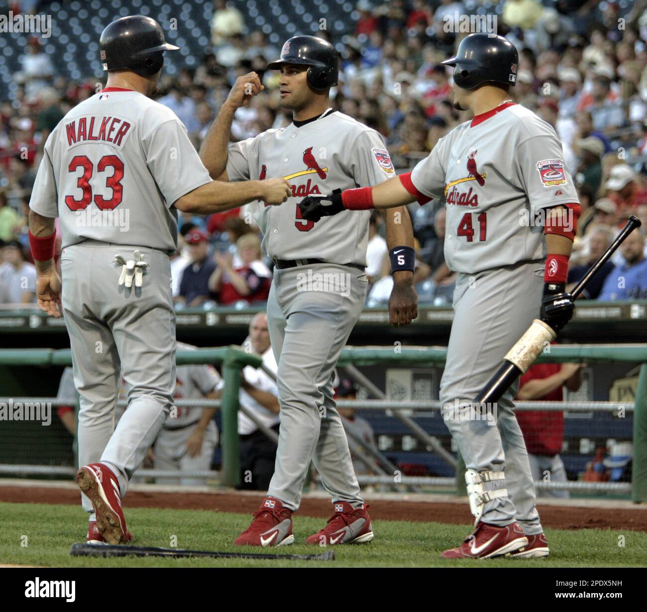 St. Louis Cardinals' Albert Pujols, center, celebrates with teammate Larry  Walker, left, and on-deck batter Yadier Molina after he and Walker scored  on a single by Cardinals' John Rodriguez during the first