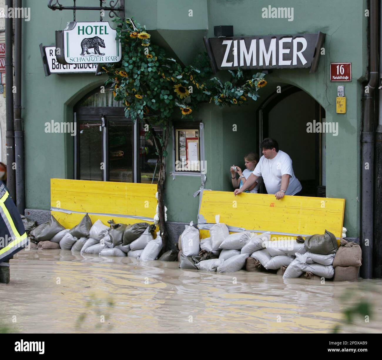 Citizens stand behind sandbags barriers looking at to the floods in