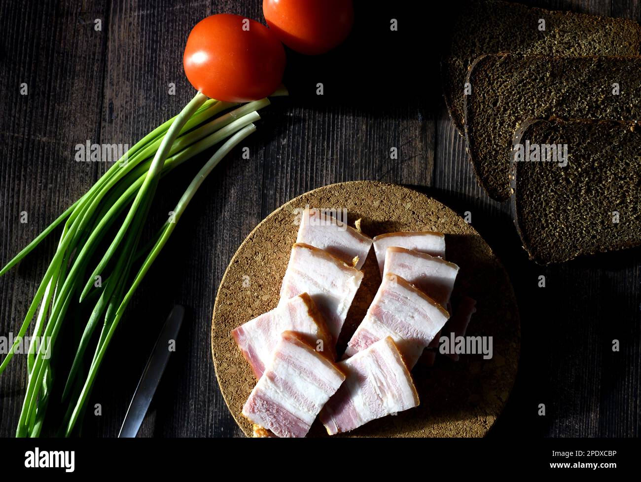 lard with black bread and green onions on a dark background, Russian