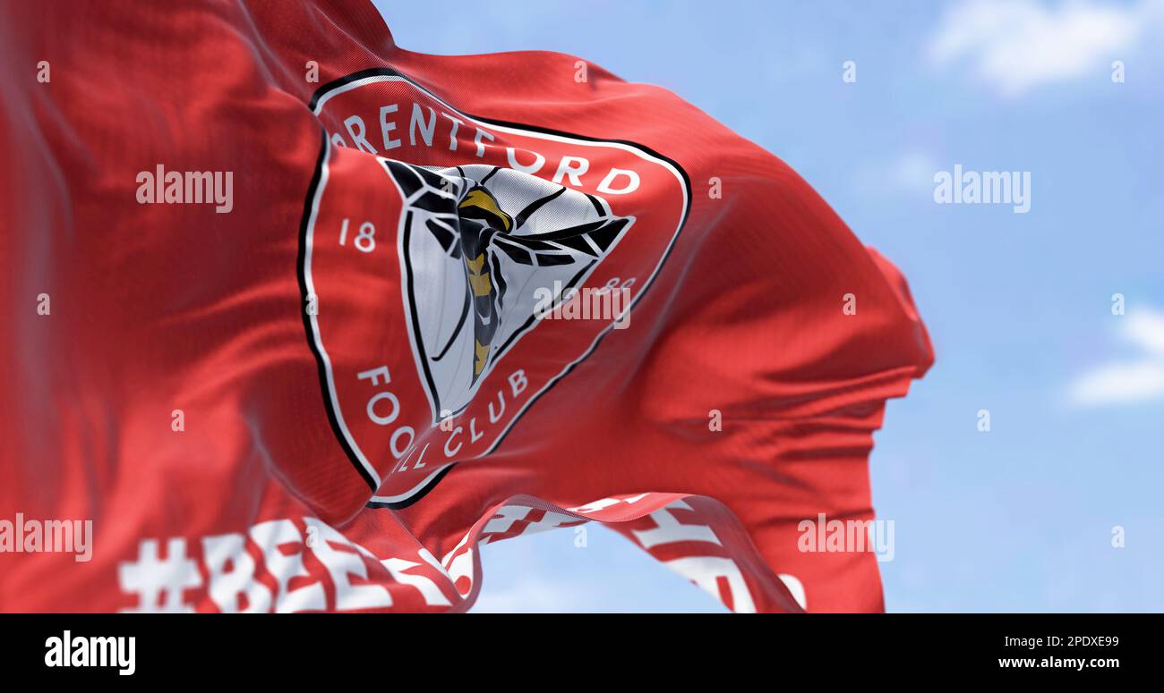 London, UK, Feb 2023: Brentford FC flag waving. Circular emblem with a bee inside on red . Rippled fabric background. Illustrative editorial 3d illust Stock Photo