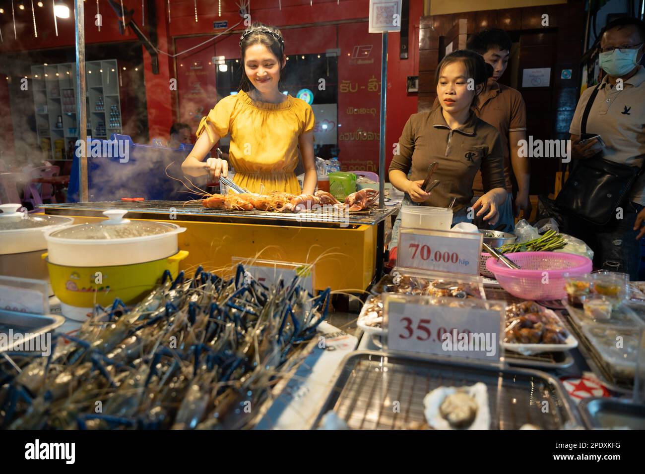 Vientiane, Laos. 14th Mar, 2023. Vendors sell food at a night market in