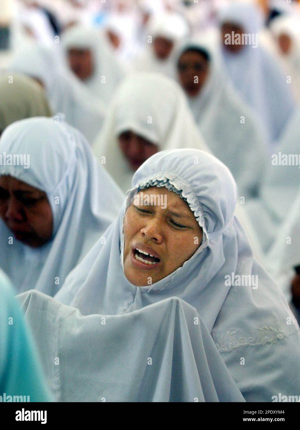 An Acehnese woman cries during a special mass prayer for peace at Baiturahman mosque in Banda Aceh, Indonesia, Monday, Aug. 15, 2005. People in Aceh were hopeful that an accord being signed Monday in Finland would bring lasting peace to their tsunami-ravaged province, but after three decades of fighting fear and distrust run deep. (AP Photo/ Achmad Ibrahim) Stock Photo