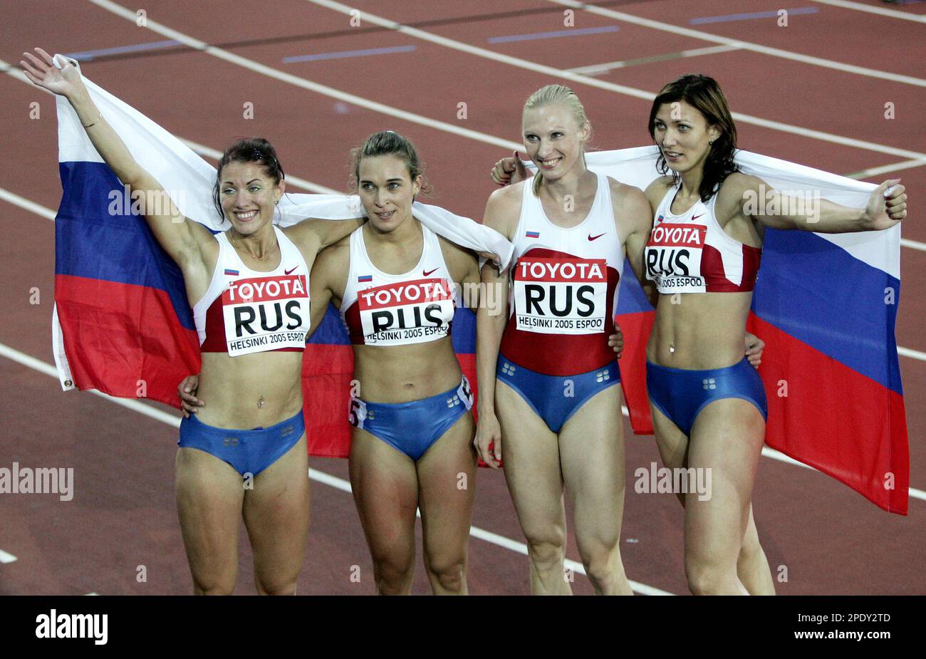 Members of the Russian relay team pose with their national flag after