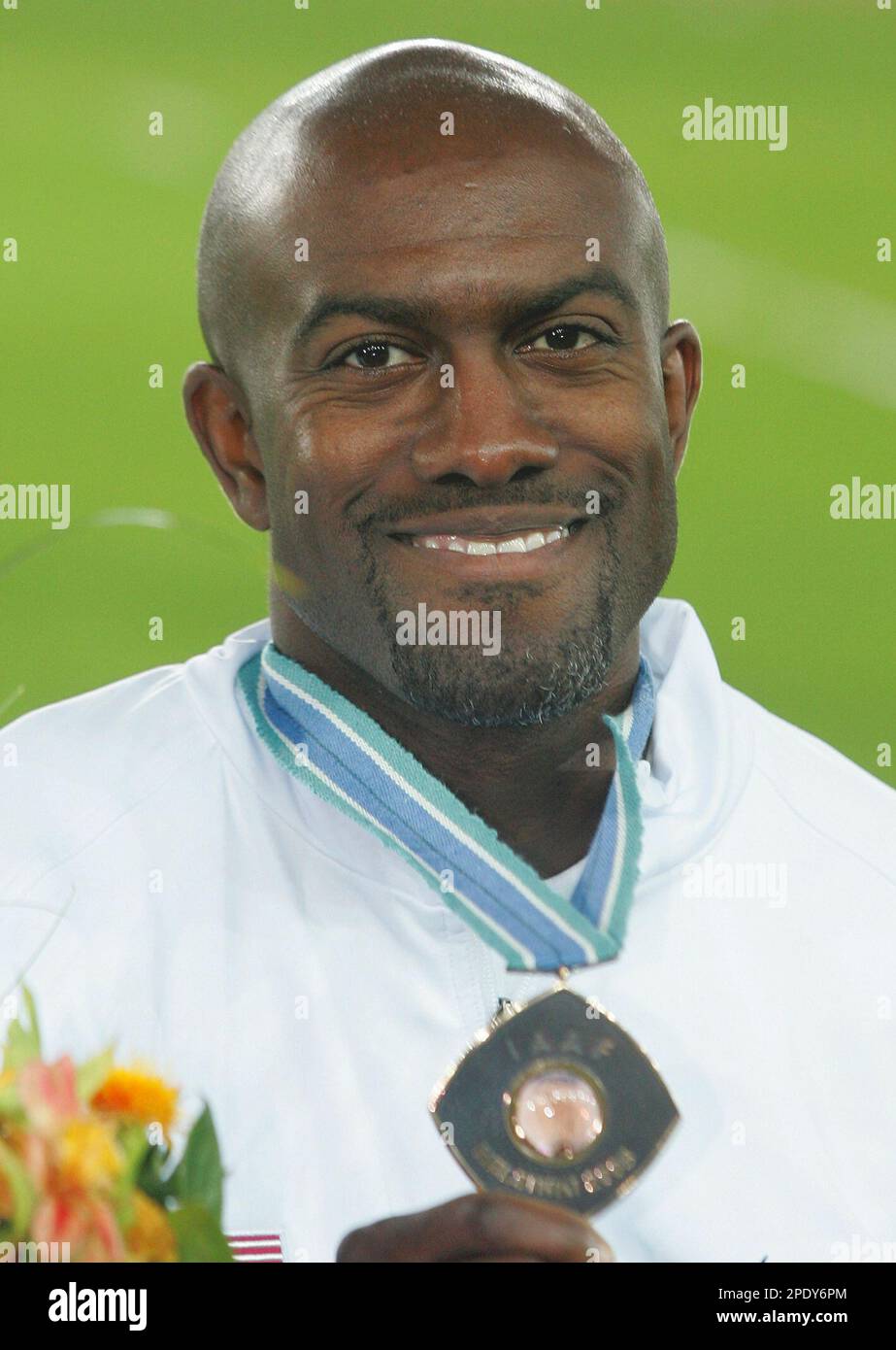 Allen Johnson of the USA poses with the bronze medal he won in the 110 ...