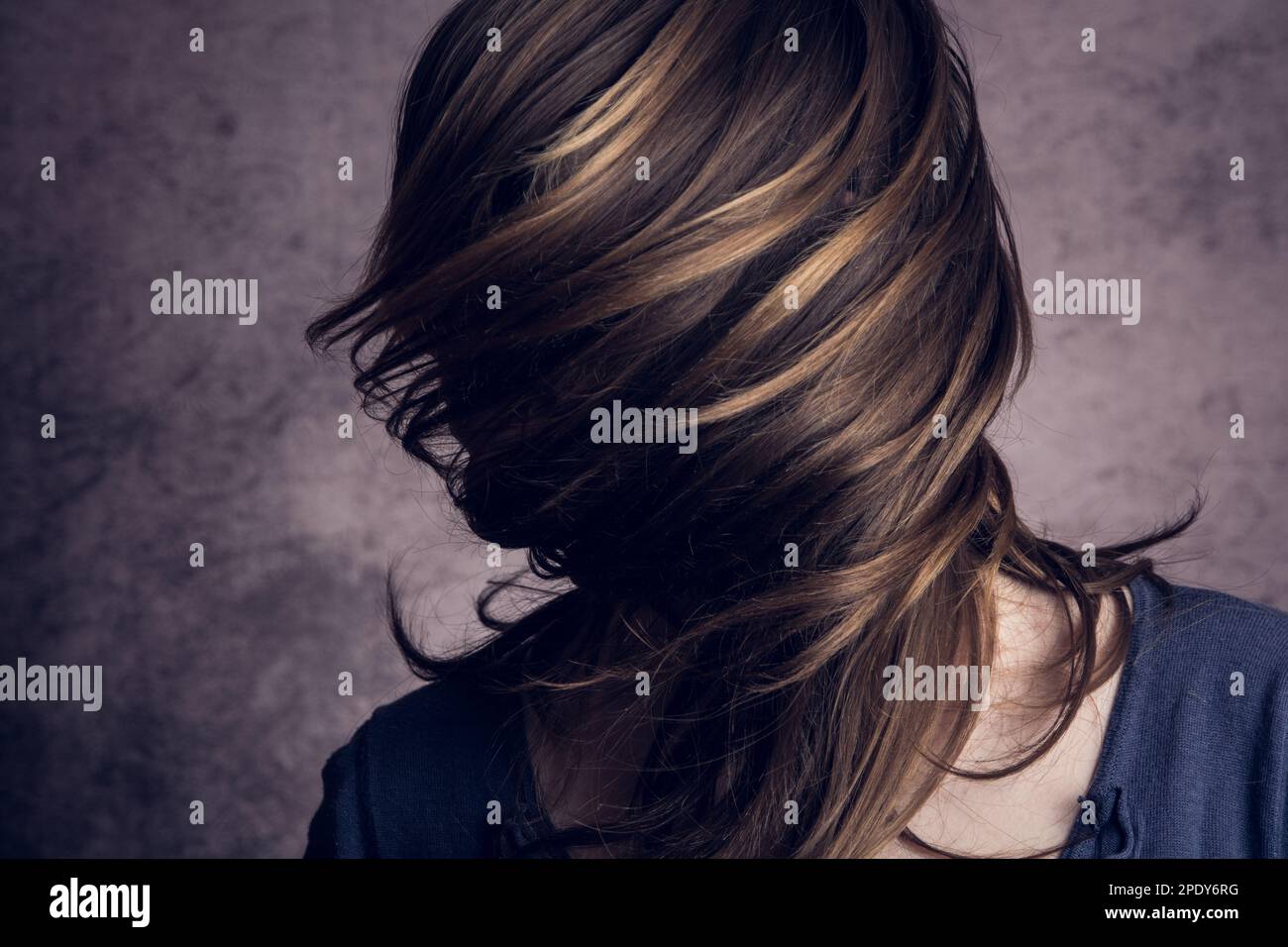 Model girl in the studio. Her face is covered by her hair. Stock Photo