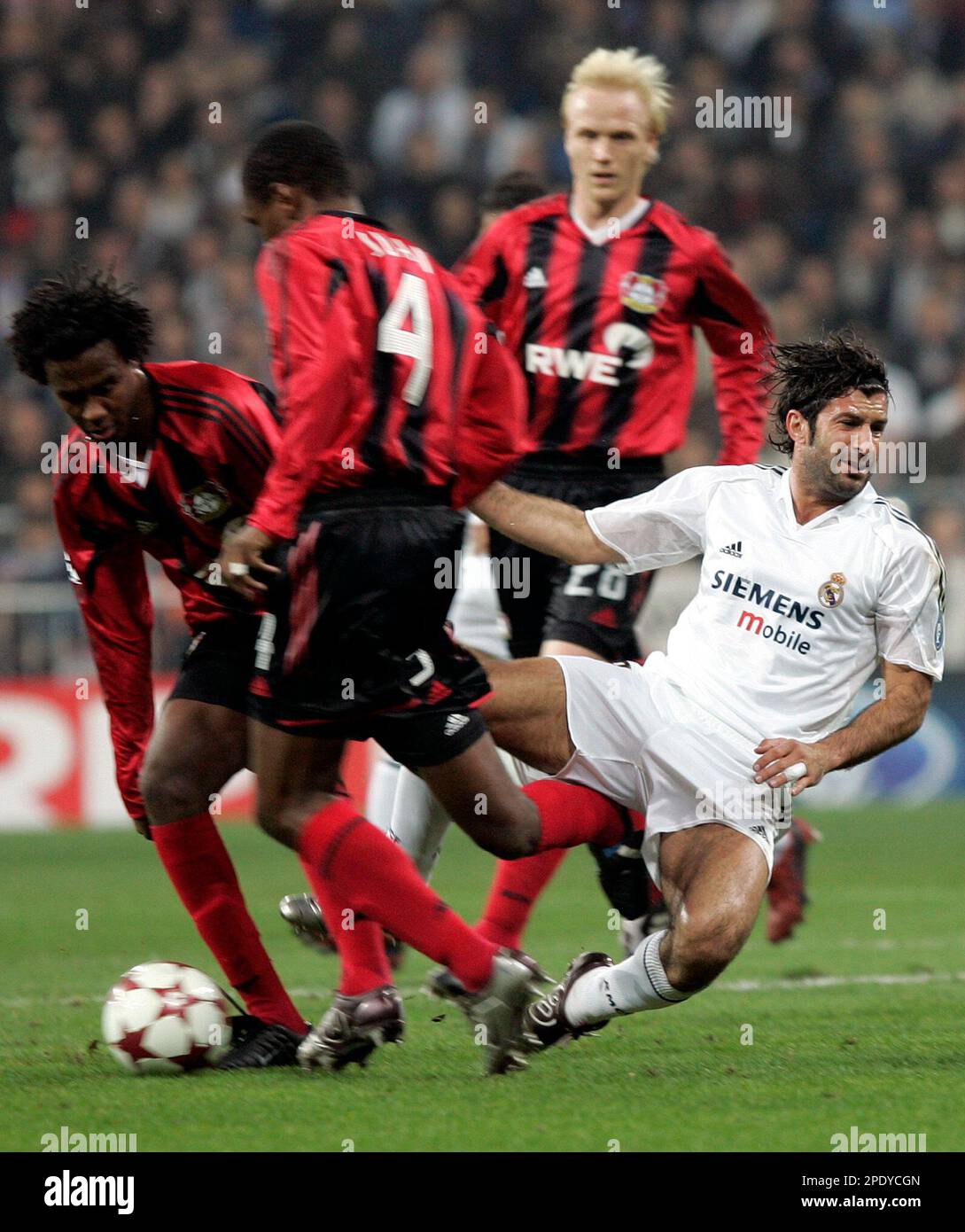 Real Madrids Portuguese player Luis Figo right is pushed off the
