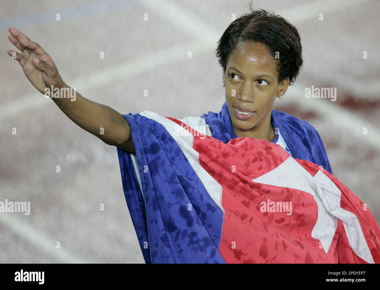 Cuba's Zulia Calatayud, wrapped in the Cuban flag, waves to the crowd