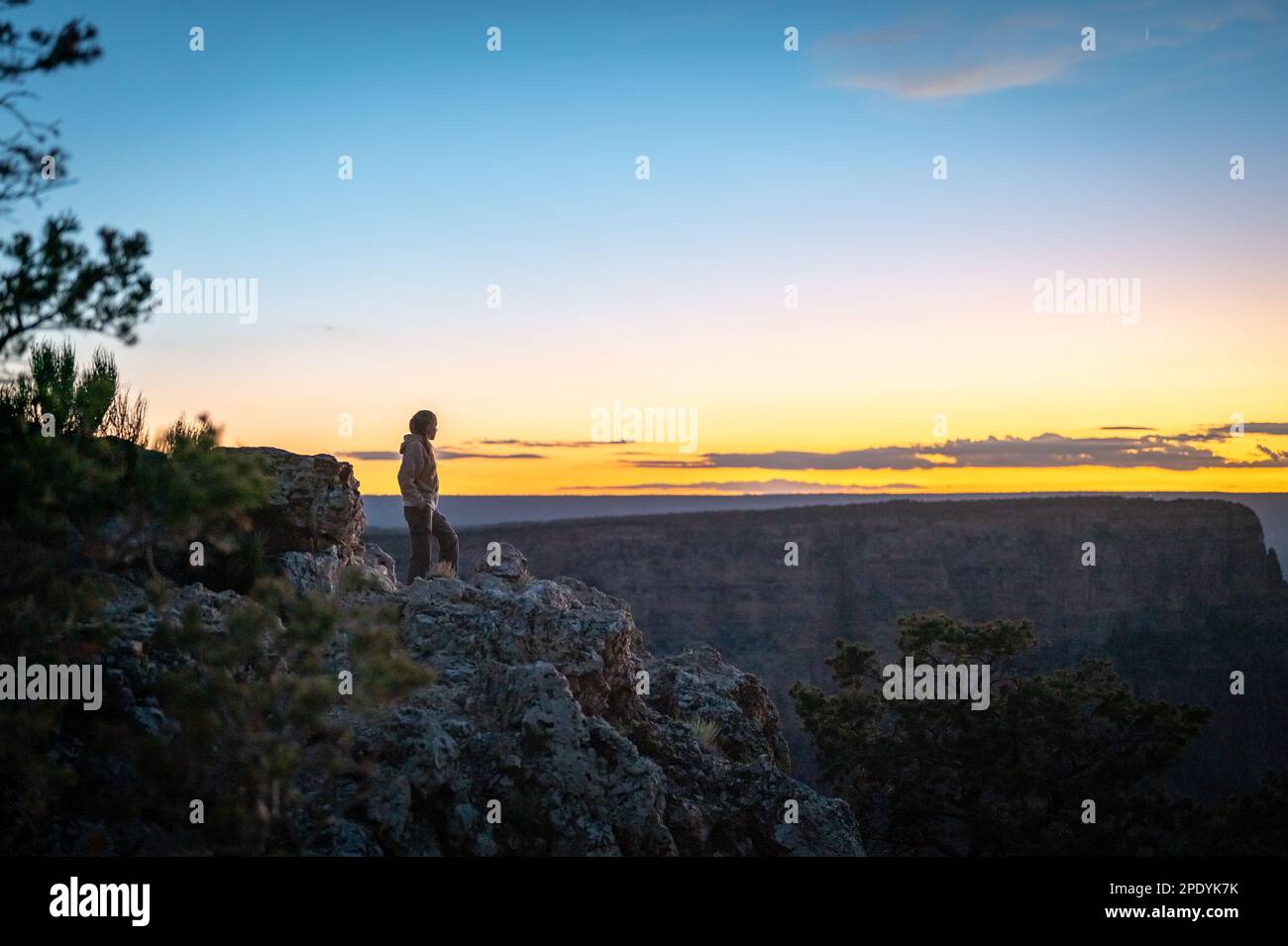 Silhouette of a young adventurer on the edge of the precipice of the ...