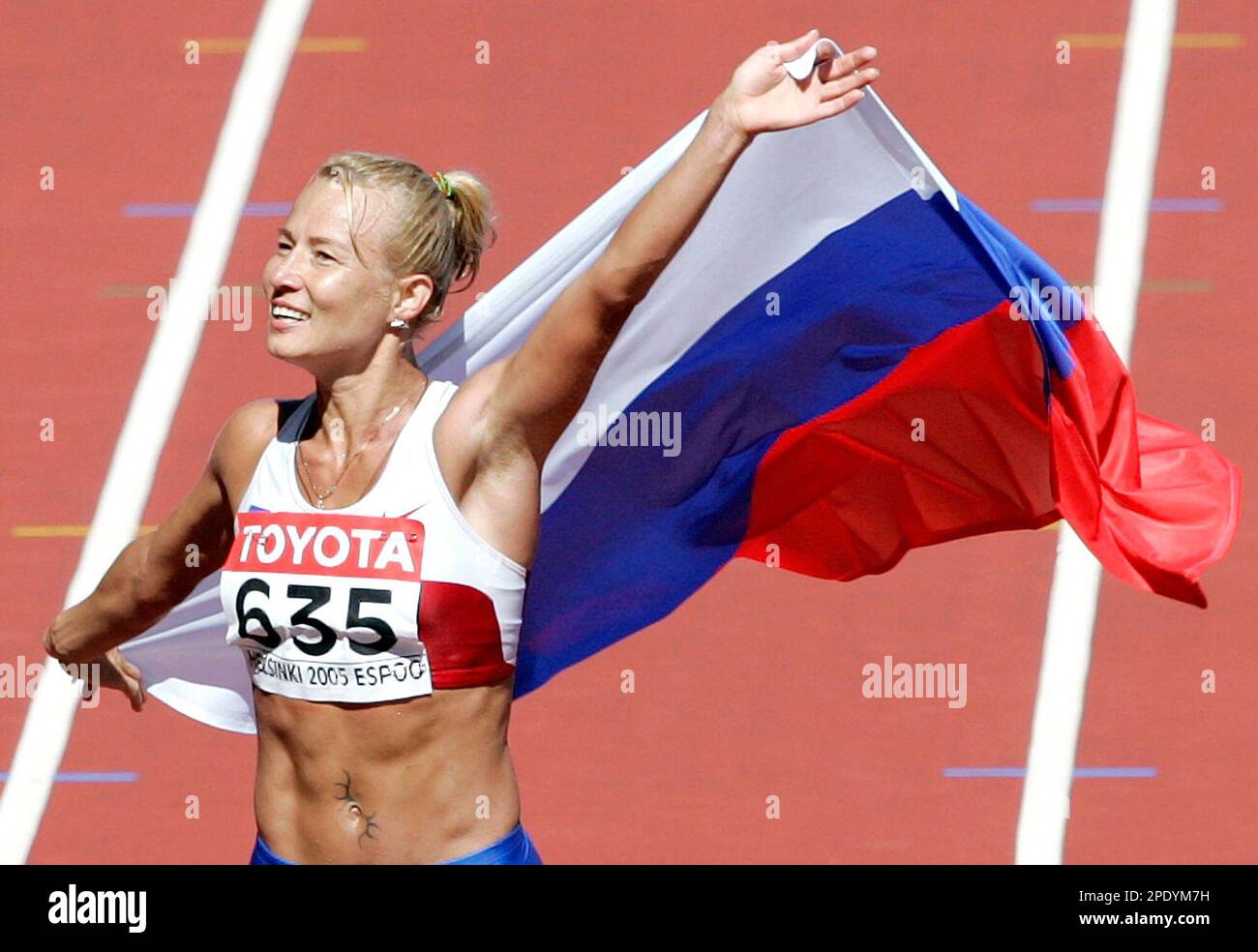 Russia's Olimpiada Ivanova celebrates with a Russian flag, after ...