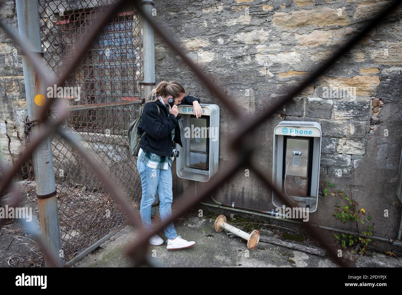 Young girl using the old abandoned phone booths of the Old Joliet Prison Stock Photo
