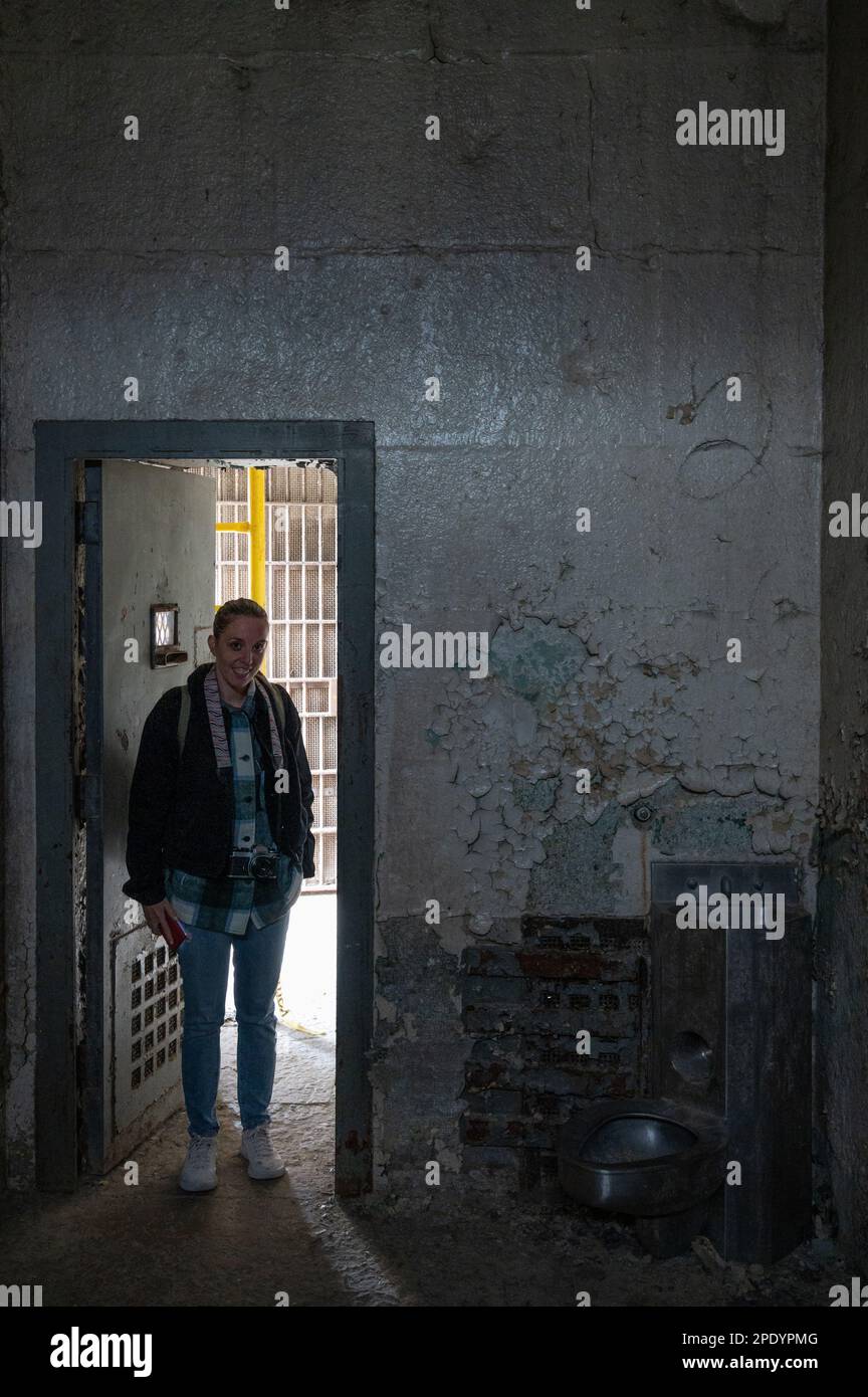 a young girl visiting the dark maximum security cell of Old Joliet Prison Stock Photo