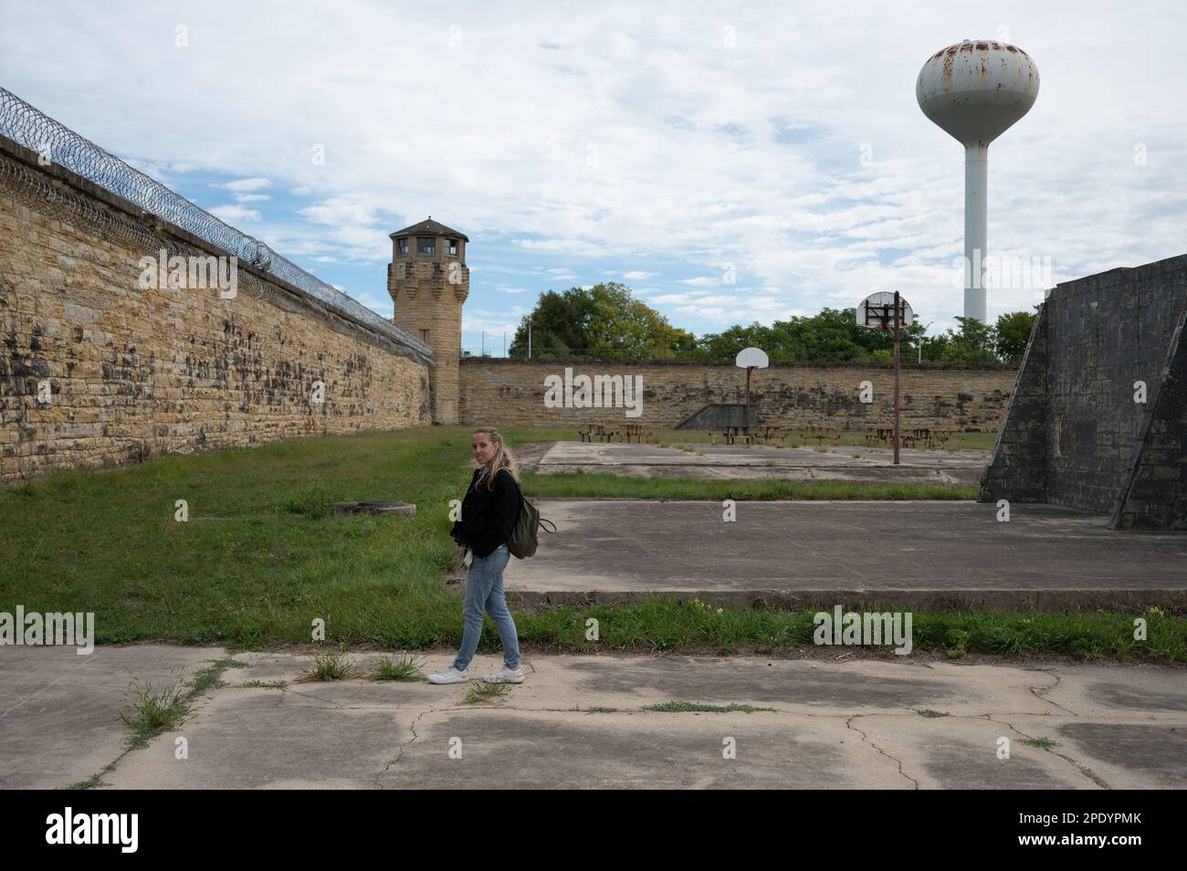 Young tourist girl with backpack visiting Old Joliet Prison, a former abandoned jail Stock Photo