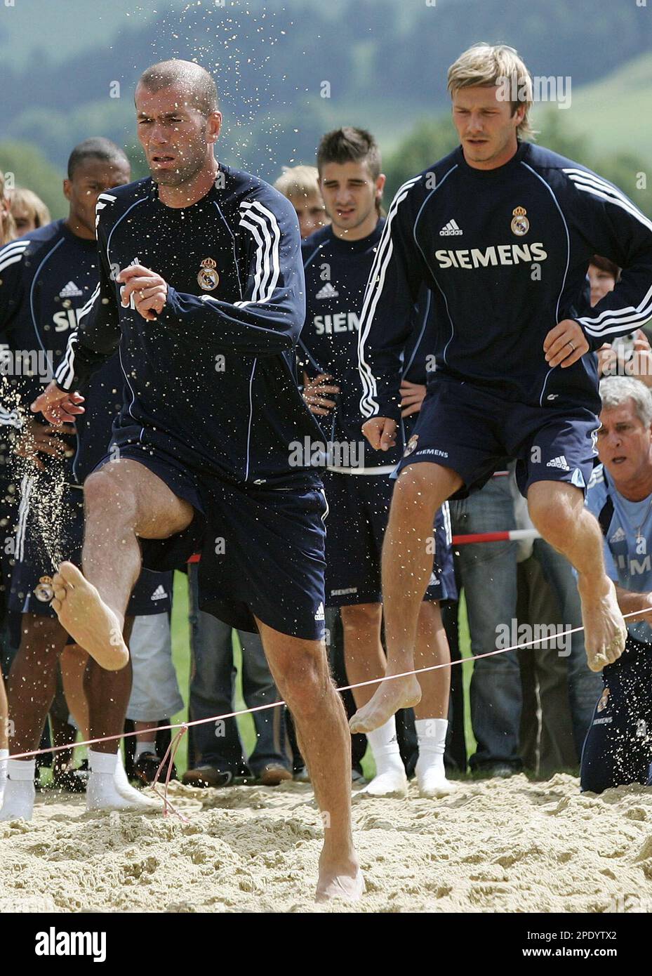 Real Madrid's Zinedine Zidane, front, and David Beckham jump in sand during a Real Madrid pre-season trainingcamp in the Austrian town of Irdning Friday, Aug. 4 2005. (AP Photo/Andreas Schaad) Stock Photo