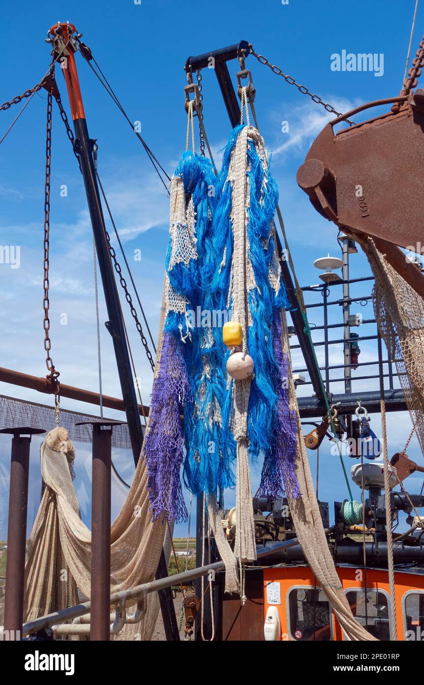 Fishing nets hanging on the beam trawler 'Sea Dog' (BN2) moored at Brancaster Staithe Quay, Norfolk, England. Stock Photo