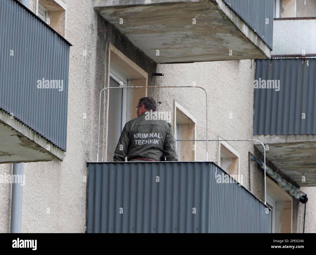 Ein Polizist steht auf einem Balkon einer Mietwohnung in Eisenhuettenstadt  am Mittwoch, 3. August 2005. Mit Hilfe einer Hundestaffel durchsuchten  Kriminaltechniker die ehemalige Wohnung einer der Toetung von neun  Neugeborenen beschuldigten Frau