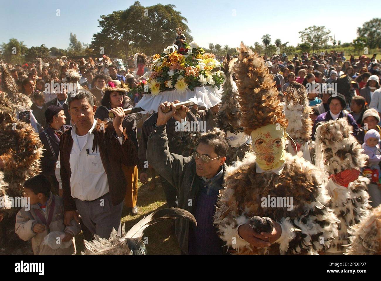 A small statue of San Francisco Solano is carried by participants, some of  them dressed in feathers as a religious promise to him, during a ceremony  in Emboscada, some 30 milles south